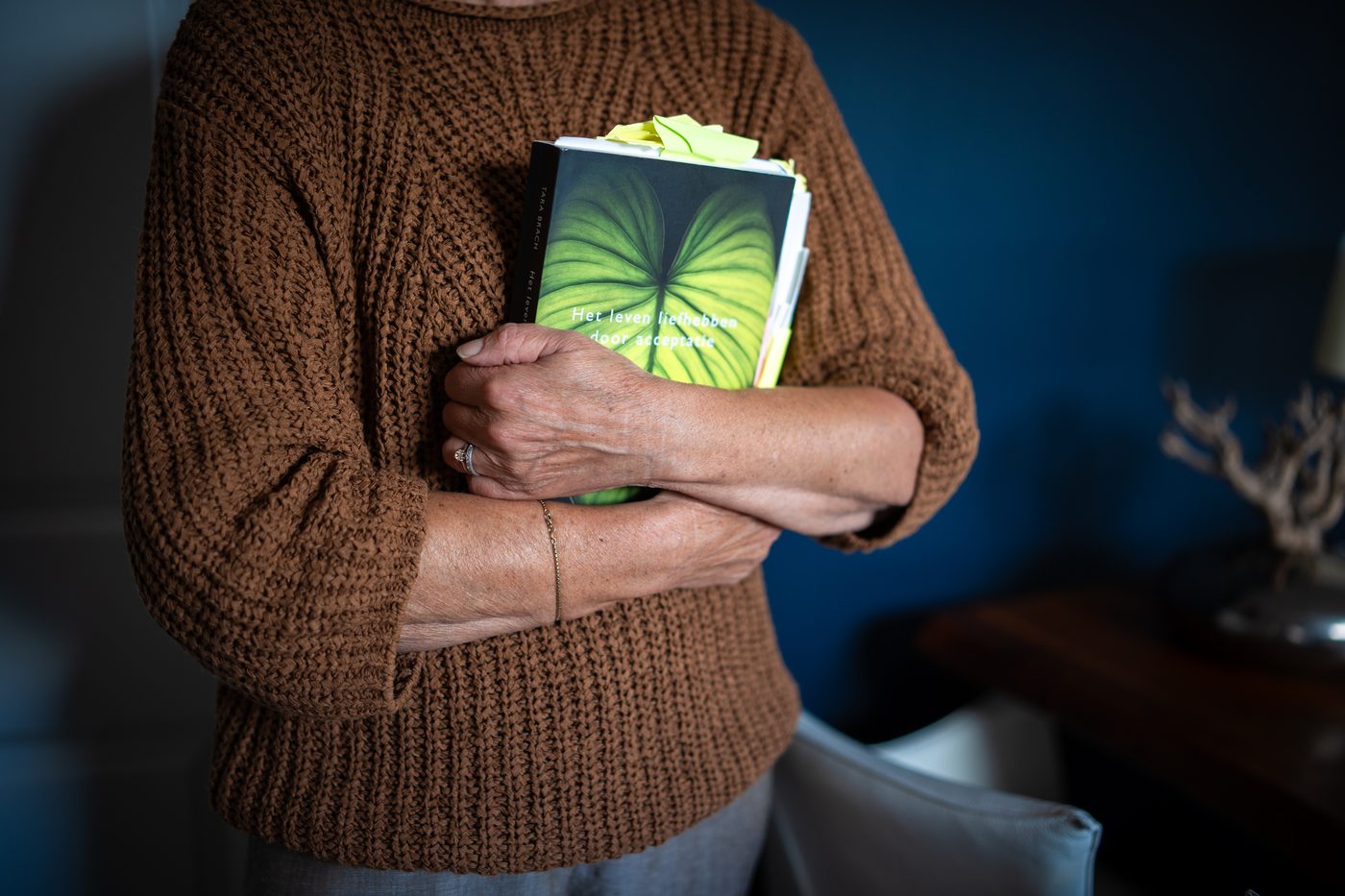 Rita met een boek in haar praktijk
