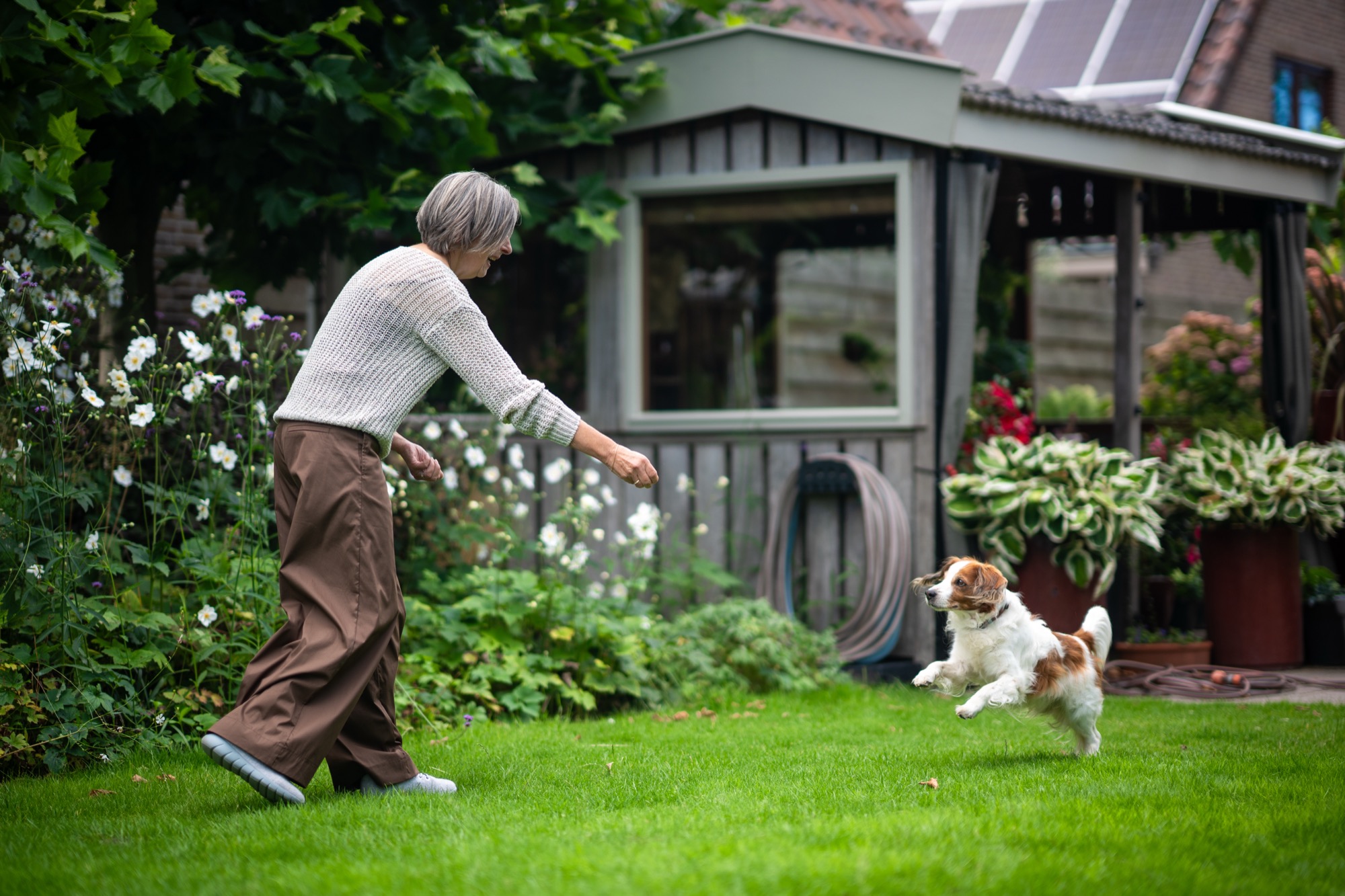 Rita van der Laag speelt met haar hond in de tuin bij de praktijk